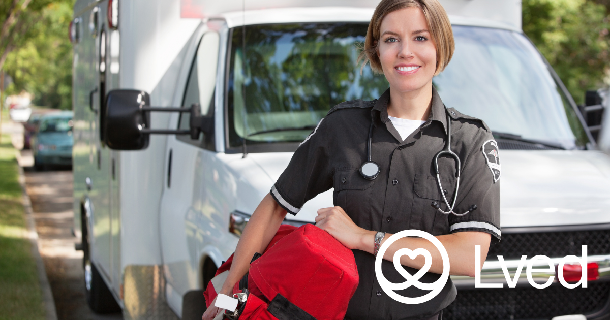 Nurse smiles in fron of an ambulance