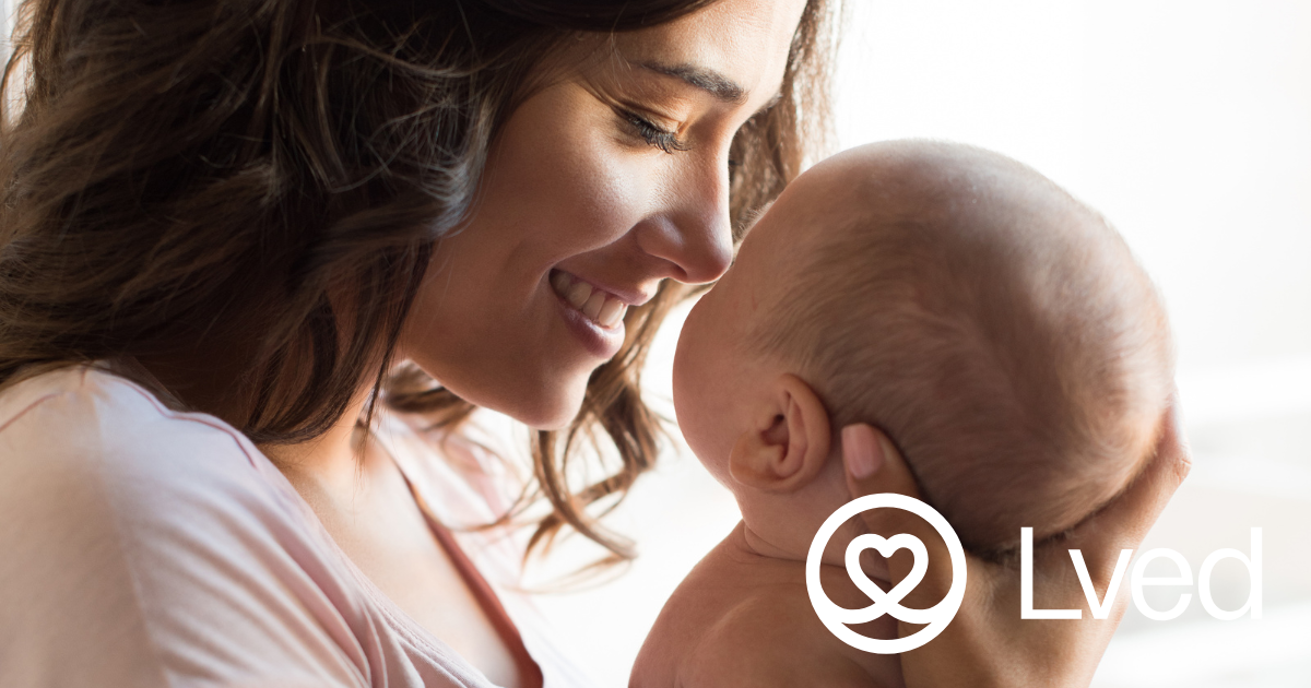 Mother holding her baby face to face and smiling